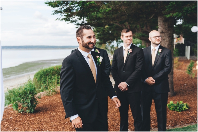 Groom excited to see his bride walking down the aisle in a outdoor beach wedding ceremony