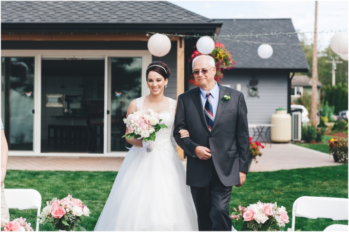 Bride and father walking down the aisle in an outdoor beach wedding ceremony