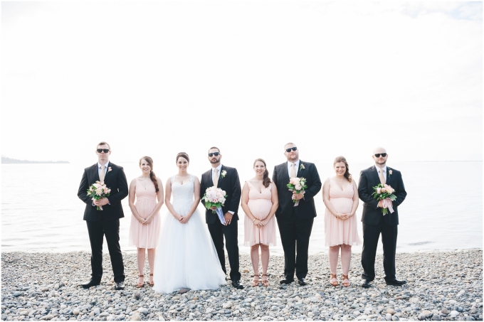 Wedding party photo on the beach in Bellingham. Guys are wearing sunglasses and holding the bouquets