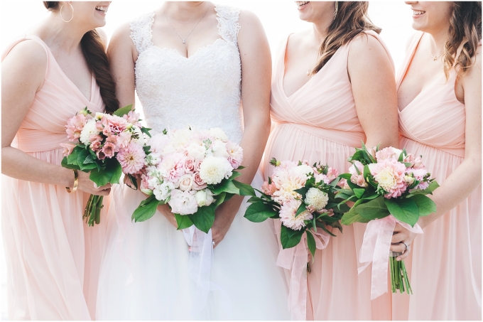 Closeup photo of bride with bridesmaids on the beach in Bellingham wearing blush dresses and  wedding bouquets