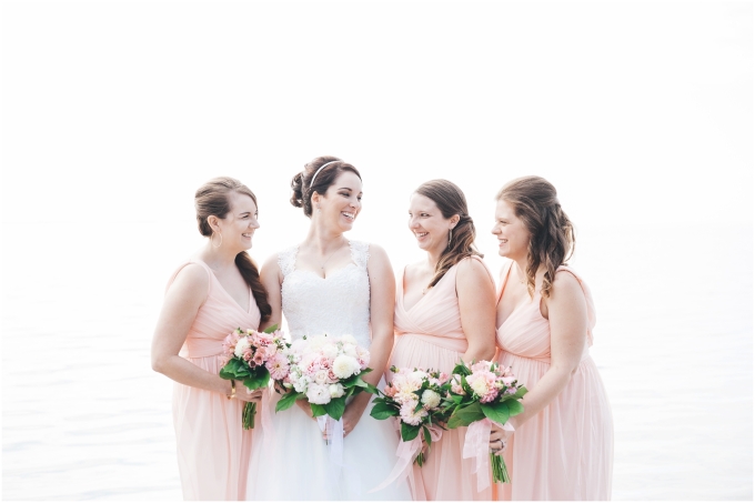Photo of bride with bridesmaids on the beach in Bellingham wearing blush dresses and  wedding bouquets