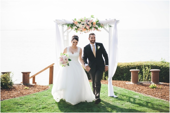 Bride and groom entering their reception in an outdoors backyard beach wedding